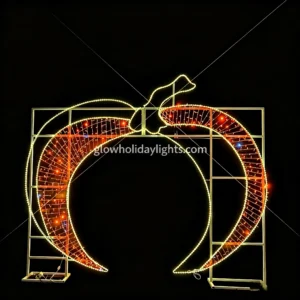 Large glowing crescent moon arch LED motif light, perfect for Christmas and holiday decor. Features warm yellow outline lights and red inner mesh lights, mounted on a sturdy metal frame. Ideal for entrances, parks, and commercial venues to create a festive night atmosphere.
