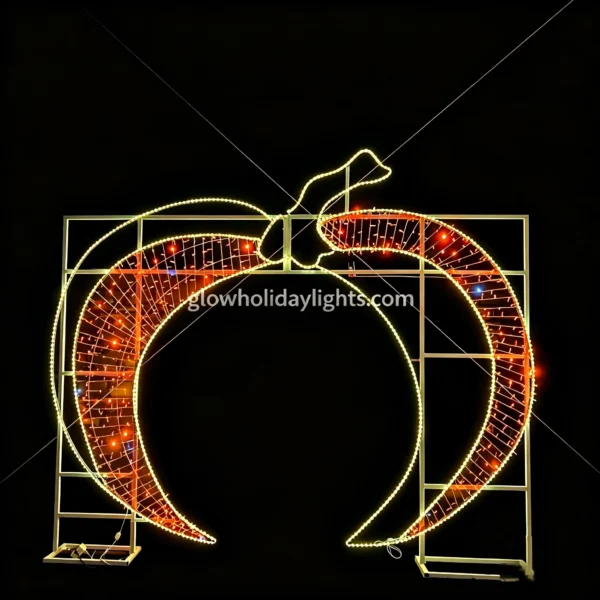 Large glowing crescent moon arch LED motif light, perfect for Christmas and holiday decor. Features warm yellow outline lights and red inner mesh lights, mounted on a sturdy metal frame. Ideal for entrances, parks, and commercial venues to create a festive night atmosphere.