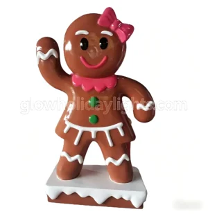This cheerful female gingerbread figure features a classic cookie design with a pink bow, icing details, and a waving pose. A charming Christmas decor piece, perfect for yards, malls, and holiday displays to add a sweet, festive touch.